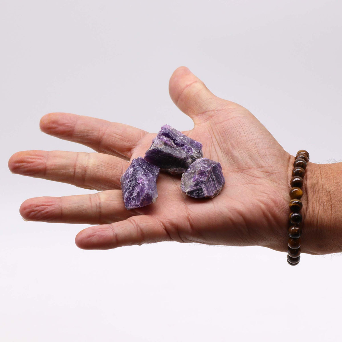 A spread of rough amethyst chunks in deep purple on cotton canvas - view 5