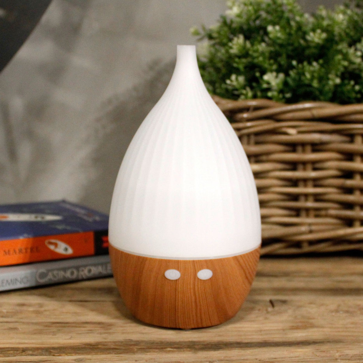 White teardrop ultrasonic aroma diffuser on a light wood base