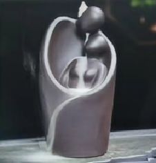 Matte black backflow burner shaped as two figures embracing, on rumpled linen - view 3