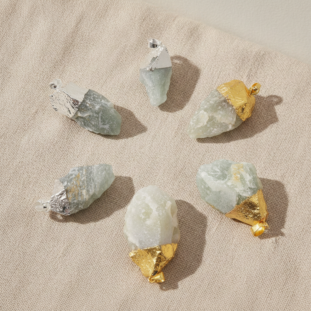 Six assorted Indian jade gold and silver plated pendants on natural linen