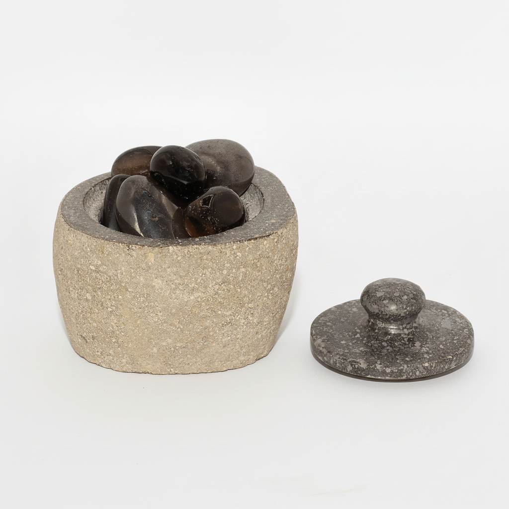 Small river stone pot with stone lid on a clean white surface against a white wall