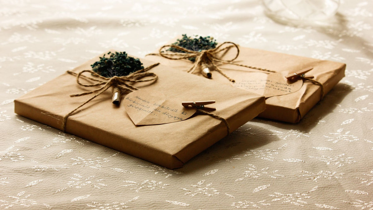 Flat parcels in kraft paper tied with twine and dried flowers