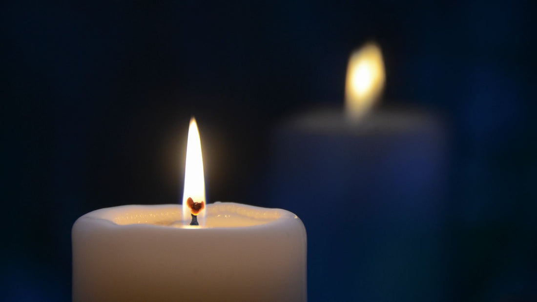 A single lit candle glowing in the dark