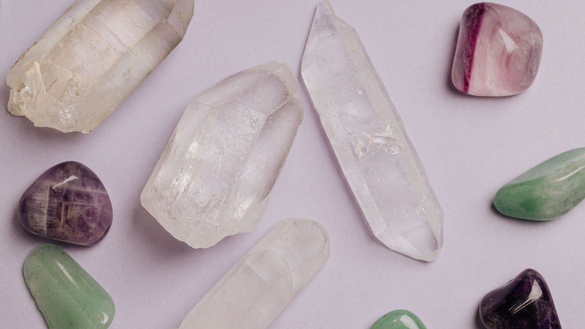 Quartz points and tumbled stones arranged on a pale background