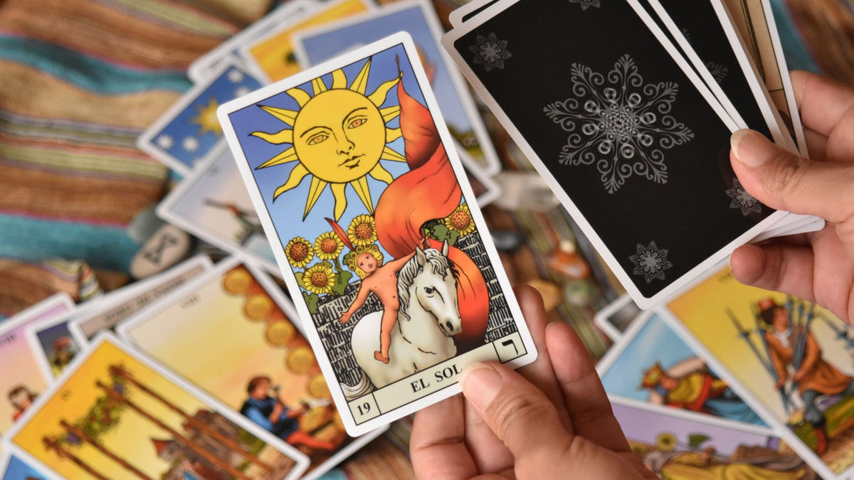 A tarot deck fanned out in both hands