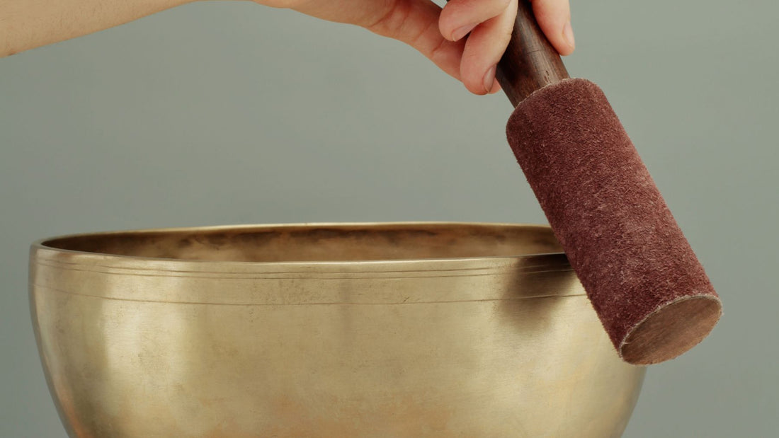 A brass singing bowl with its wooden mallet
