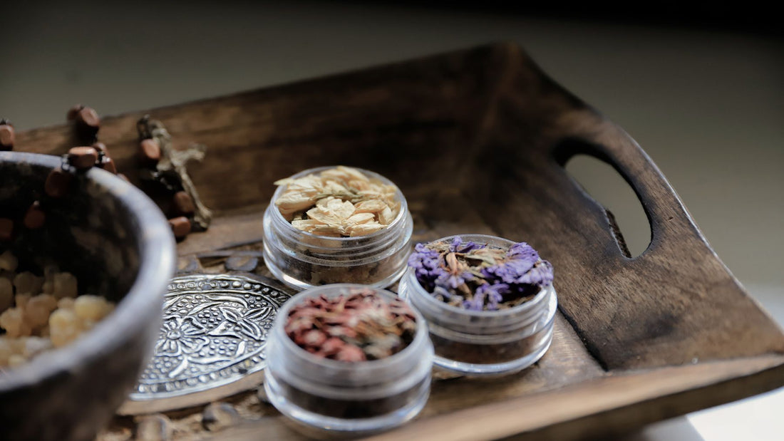 A wooden tray of loose incense resins and powders