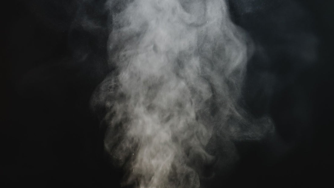 A plume of incense smoke against a dark background