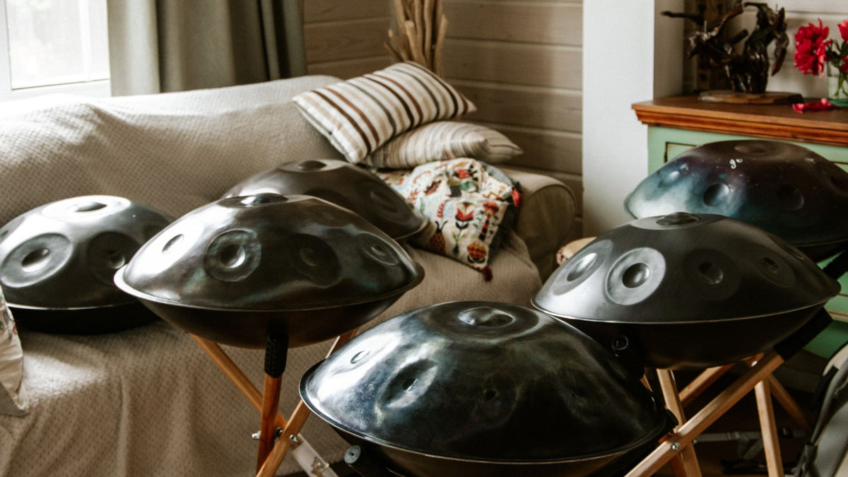 Handpan and steel tongue drums on stands in a room