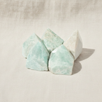 Amazonite polished crystal points, group of five on cream linen