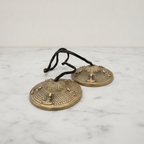 Pair of Tibetan tingsha cymbals on marble, seen from above