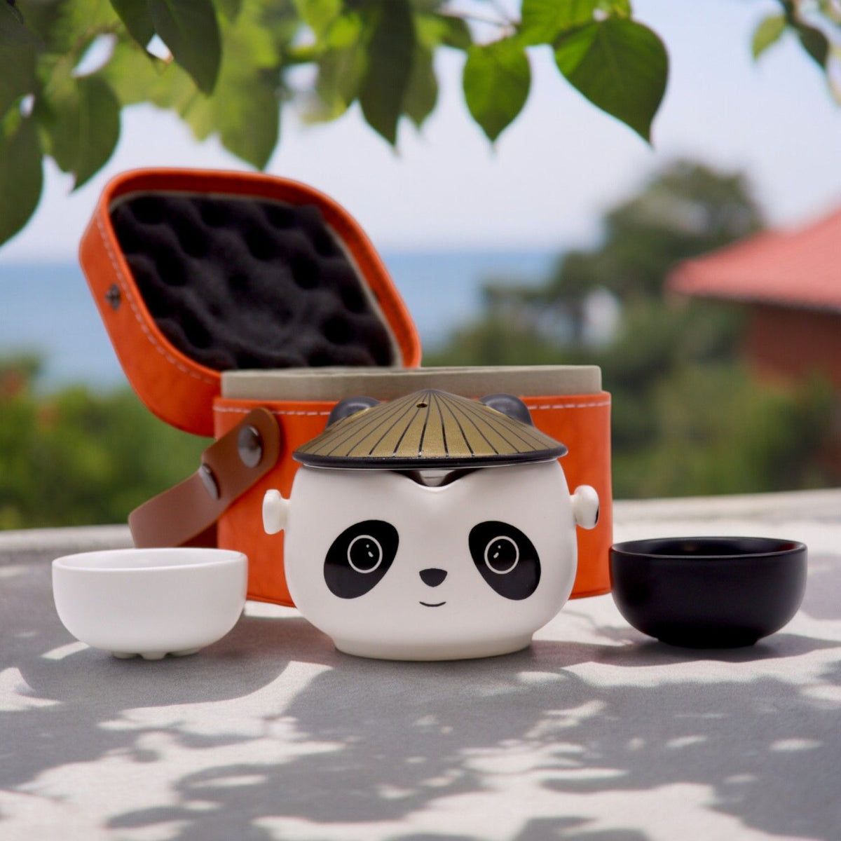 Panda-faced ceramic teapot with two cups and a golden hat lid, on cotton canvas - view 3