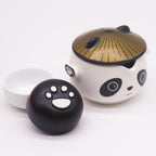 Panda-faced ceramic teapot with two cups and a golden hat lid, on cotton canvas - view 9
