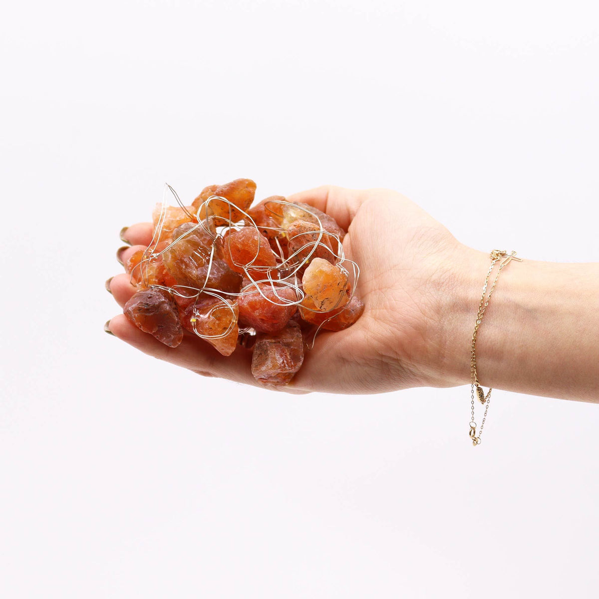 Orange jade fairy lights held in a hand