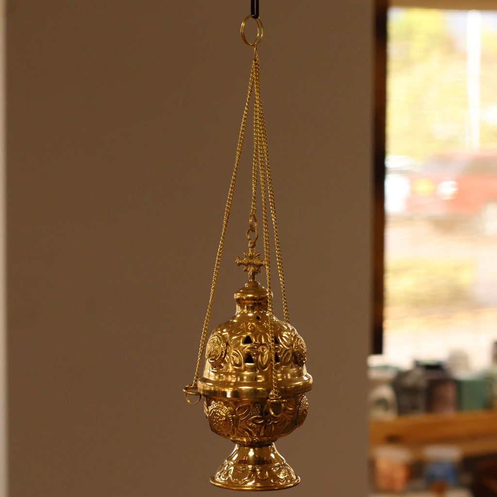 Ornate brass hanging incense burner standing on its footed base, chains beside it - view 3