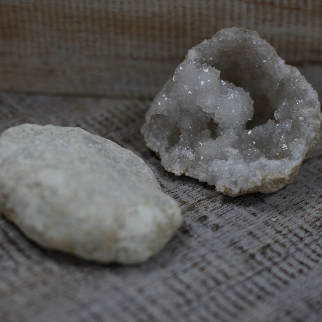 A rough unopened calcite geode resting on cotton-rag paper - view 6