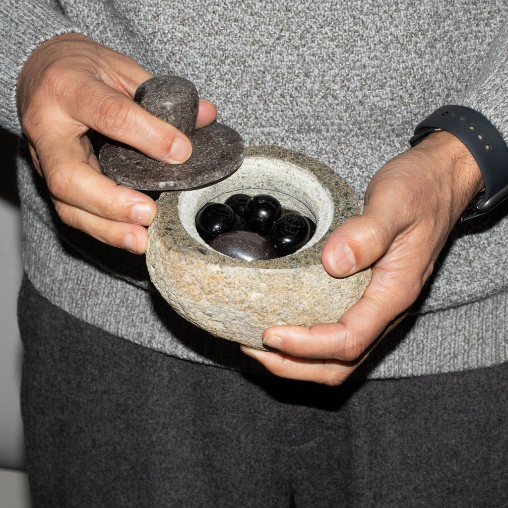 Medium grounding pot carved from a single riverstone, with a fitted stone lid, rough outside and smooth within