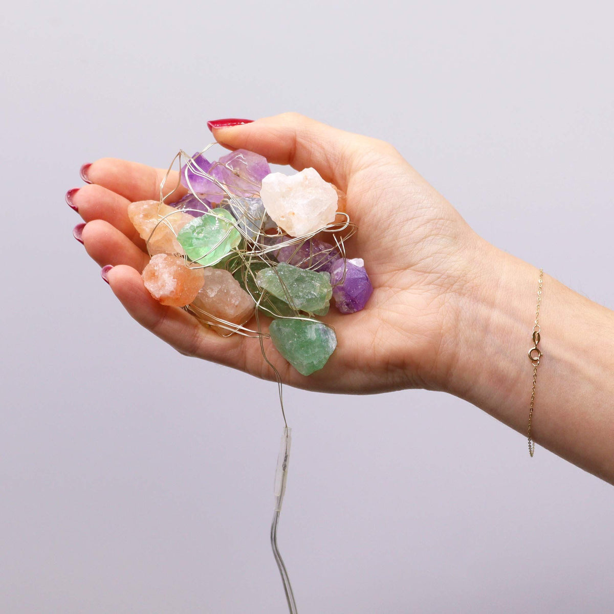 Mixed gemstone fairy lights held in a hand