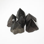Polished black tourmaline crystal points grouped together on natural linen - view 6