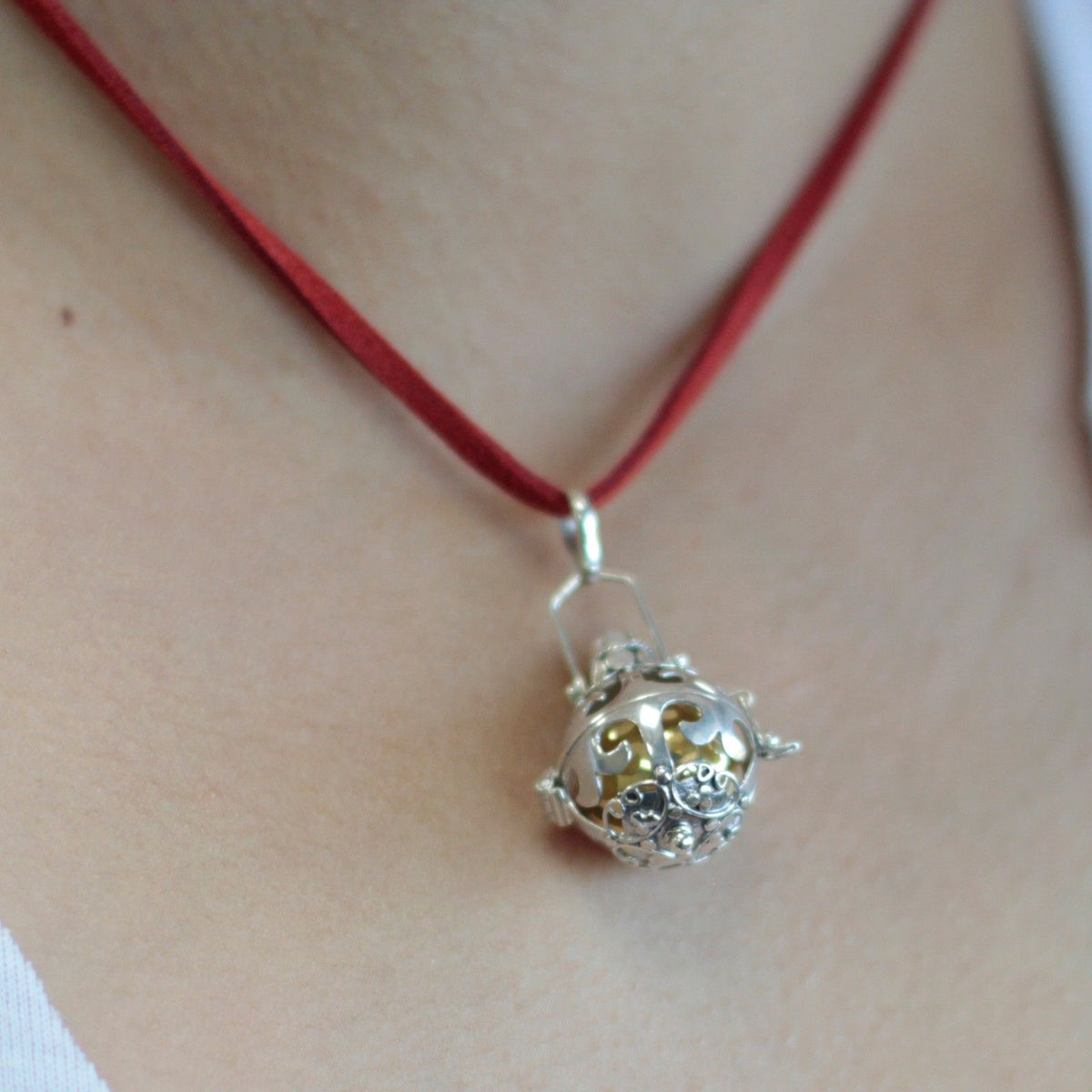Silver angel bell pendant in the Magic design on a neck cord