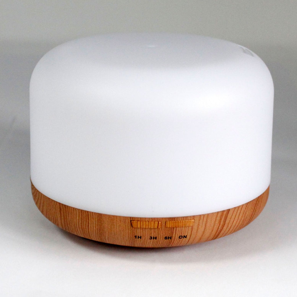 Squat white pod aroma diffuser on a wood-effect base