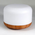Squat white pod aroma diffuser on a wood-effect base