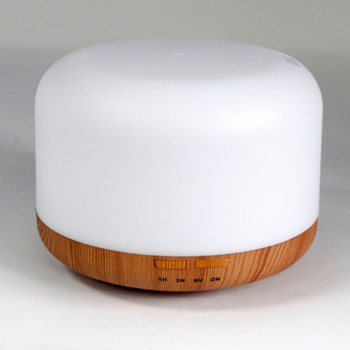 Squat white pod aroma diffuser on a wood-effect base