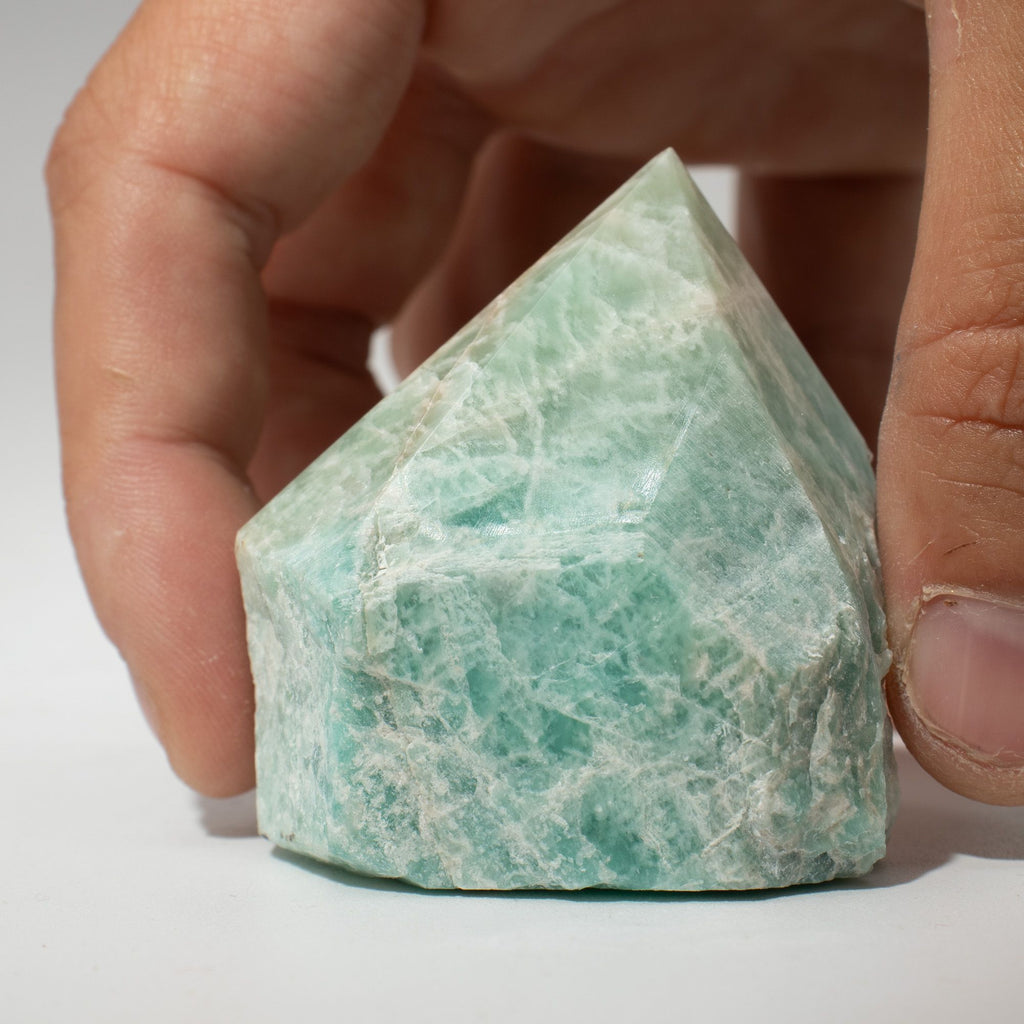 A polished green amazonite crystal point standing on cotton canvas - view 3