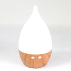 White teardrop ultrasonic aroma diffuser on a light wood base - view 4