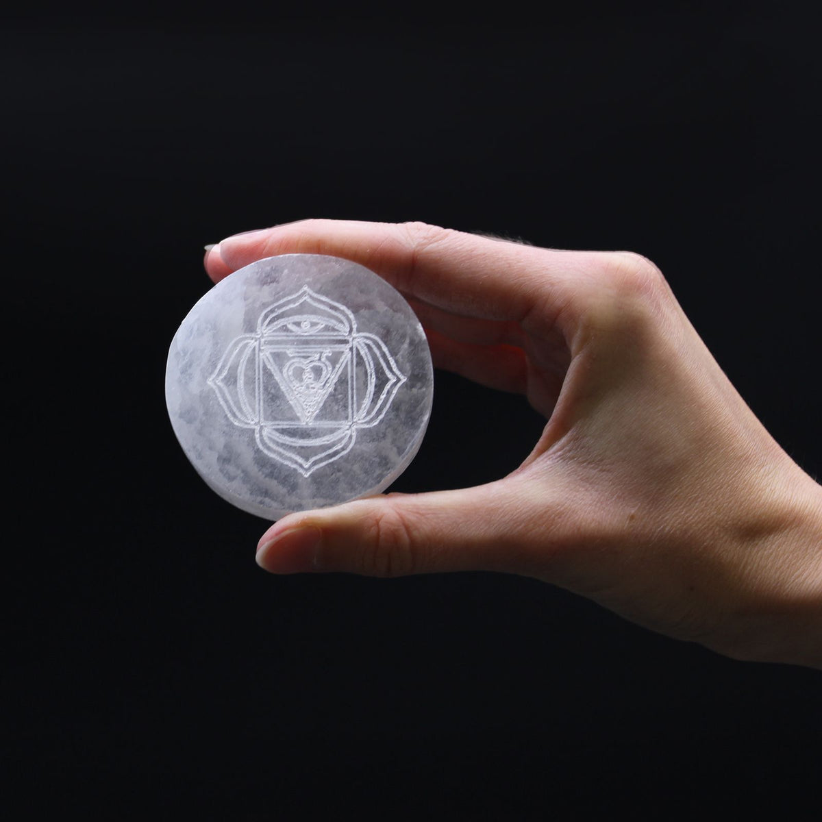 Set of seven small selenite charging plates, one engraved and coloured per chakra