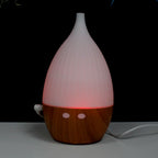 White teardrop ultrasonic aroma diffuser on a light wood base - view 5