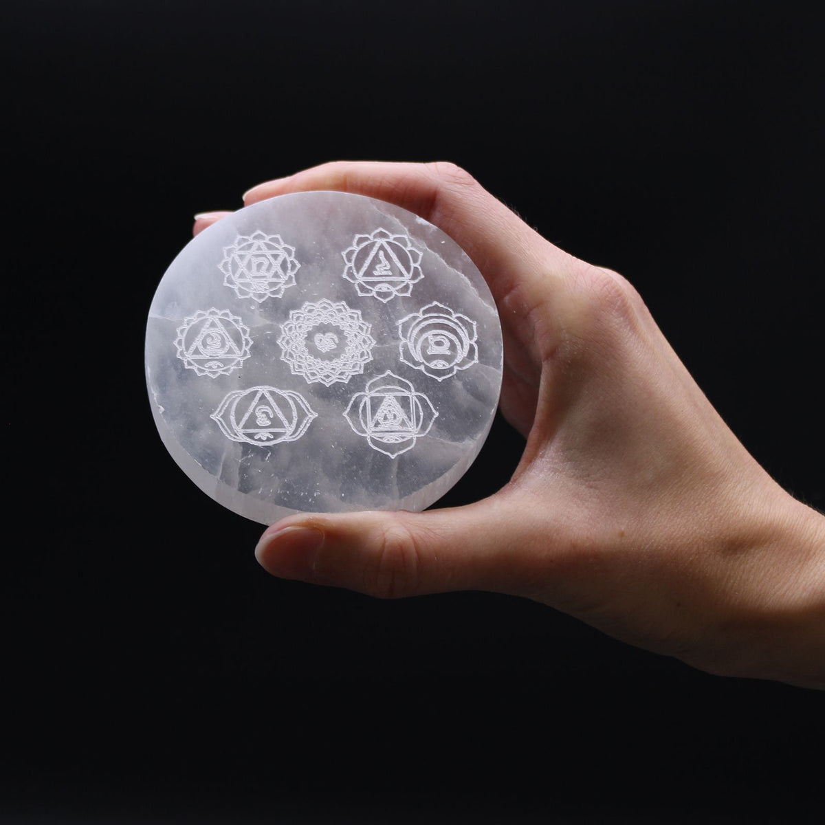 Small round selenite charging plate engraved with the seven chakra symbols