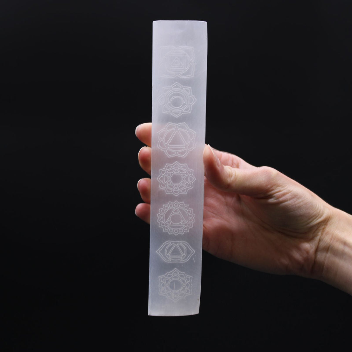Flat bar selenite charging plate with the seven chakra symbols engraved along its length