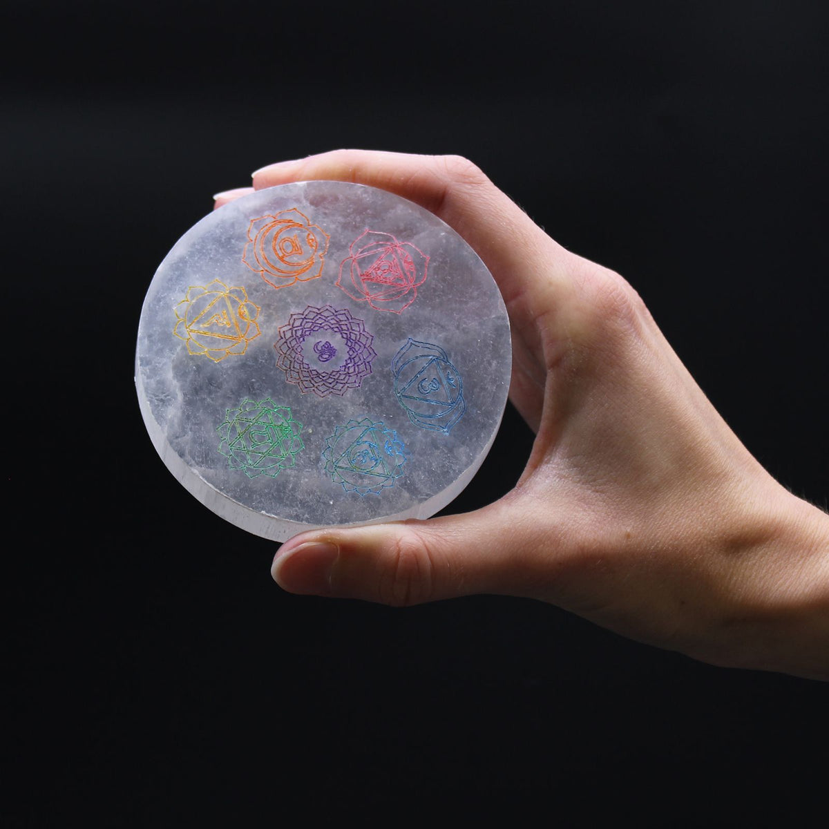 Small round selenite charging plate with the seven chakra symbols in colour - view 2