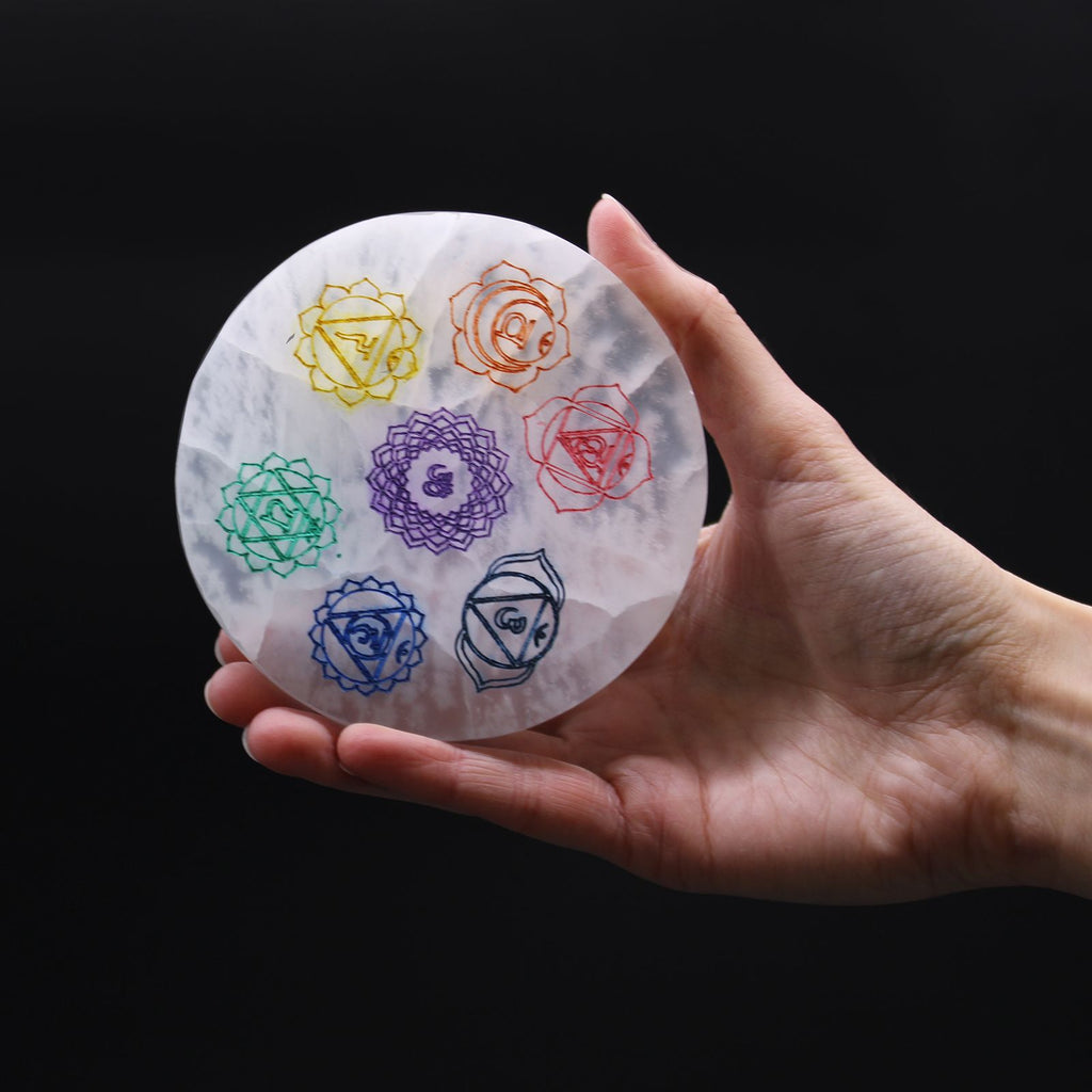 Medium round selenite charging plate with the seven chakra symbols in colour - view 2