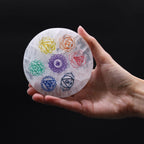 Medium round selenite charging plate with the seven chakra symbols in colour - view 2