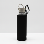 Rose quartz crystal glass water bottle with an obelisk inside on a clean white surface against a white wall
