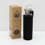 Clear quartz crystal glass water bottle on a clean white surface against a white wall