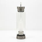 Clear quartz crystal glass water bottle on a clean white surface against a white wall