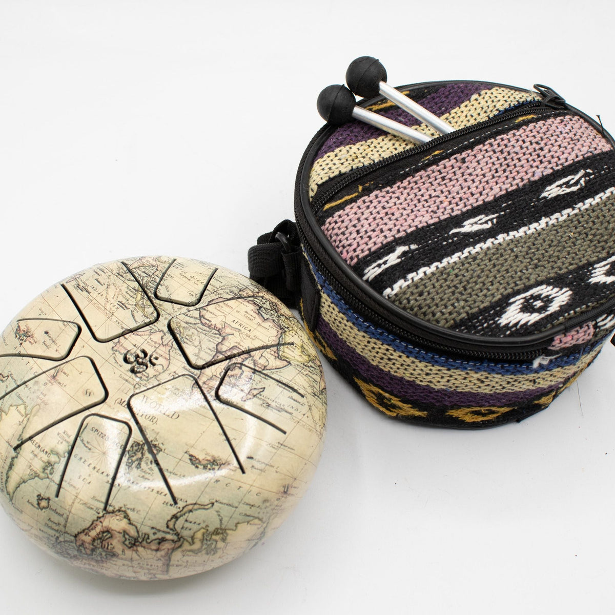 Medium Atlas tongue drum beside its striped woven carry bag with mallets tucked in the top