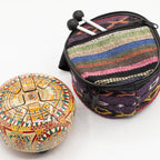 Om Mandala tongue drum beside its striped woven carry bag