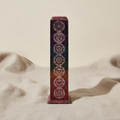 Soapstone square tower incense holder with seven chakra symbols on natural linen