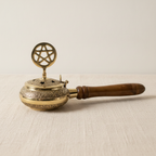Brass censer incense burner with pentagram lid and wooden handle on cotton canvas