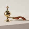 Brass censer incense burner with cross finial and wooden handle on cotton canvas