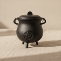 Cast iron cauldron with pentagram and lid on natural linen