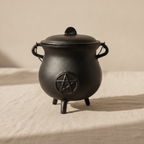 Cast iron cauldron with pentagram and lid on natural linen