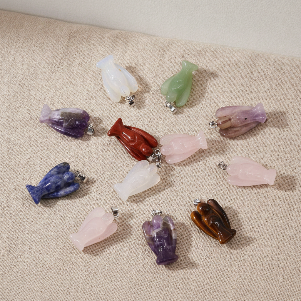 Twelve assorted gemstone mini angel pendants on natural linen