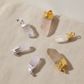Six assorted clear quartz gold and silver plated pendants on natural linen