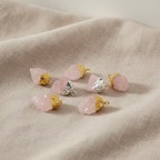 Six assorted rose quartz gold and silver plated pendants on natural linen