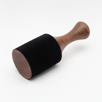 Extra large wooden king stick striker on a clean white surface against a white wall